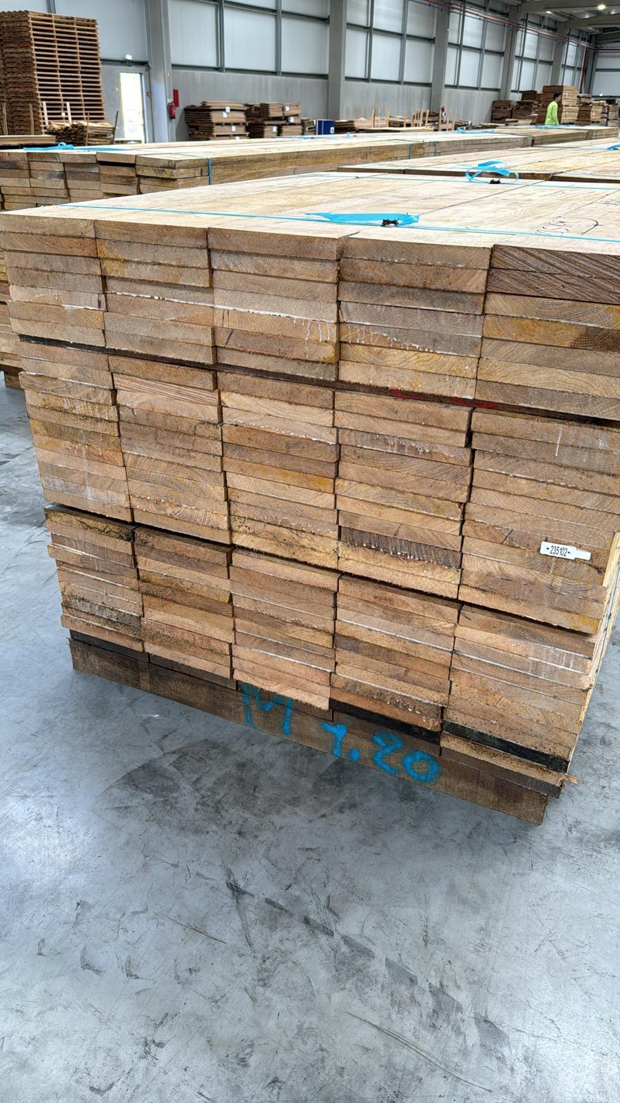 Oak edged boards stacked on pallets, warehouse storage