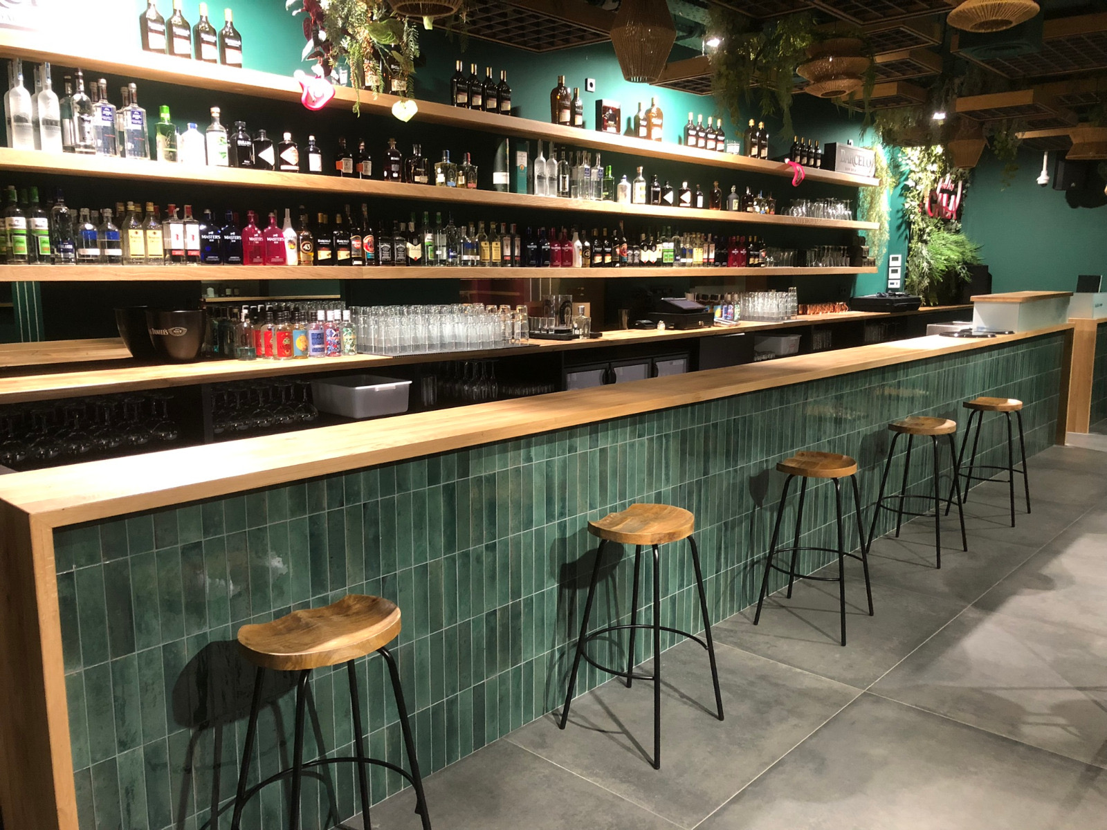 Restaurant bar with solid wood counter, shelving and bar stools
